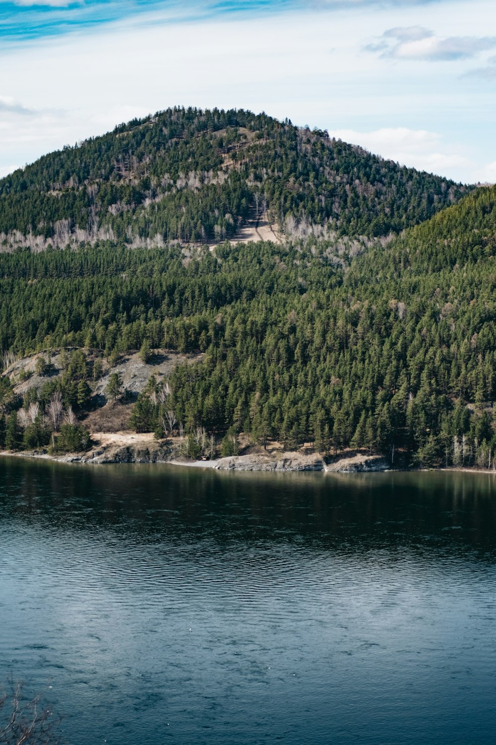 a large body of water with a mountain in the background