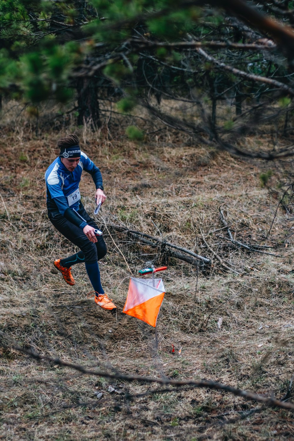 a man holding a kite in a wooded area