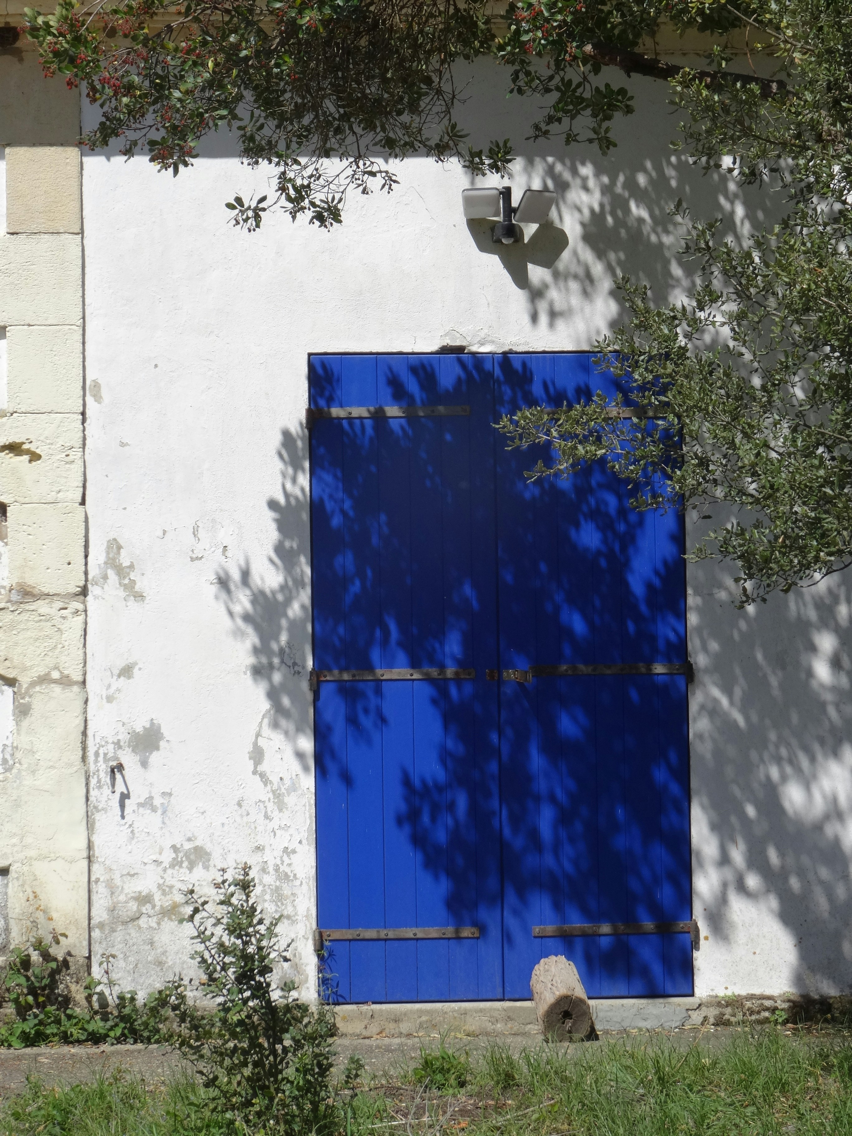 ein weißes Gebäude mit blauer Tür und blauem Fenster