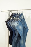 five pairs of jeans hanging on a clothes rack