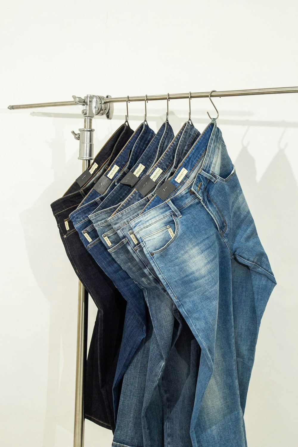 five pairs of jeans hanging on a clothes rack