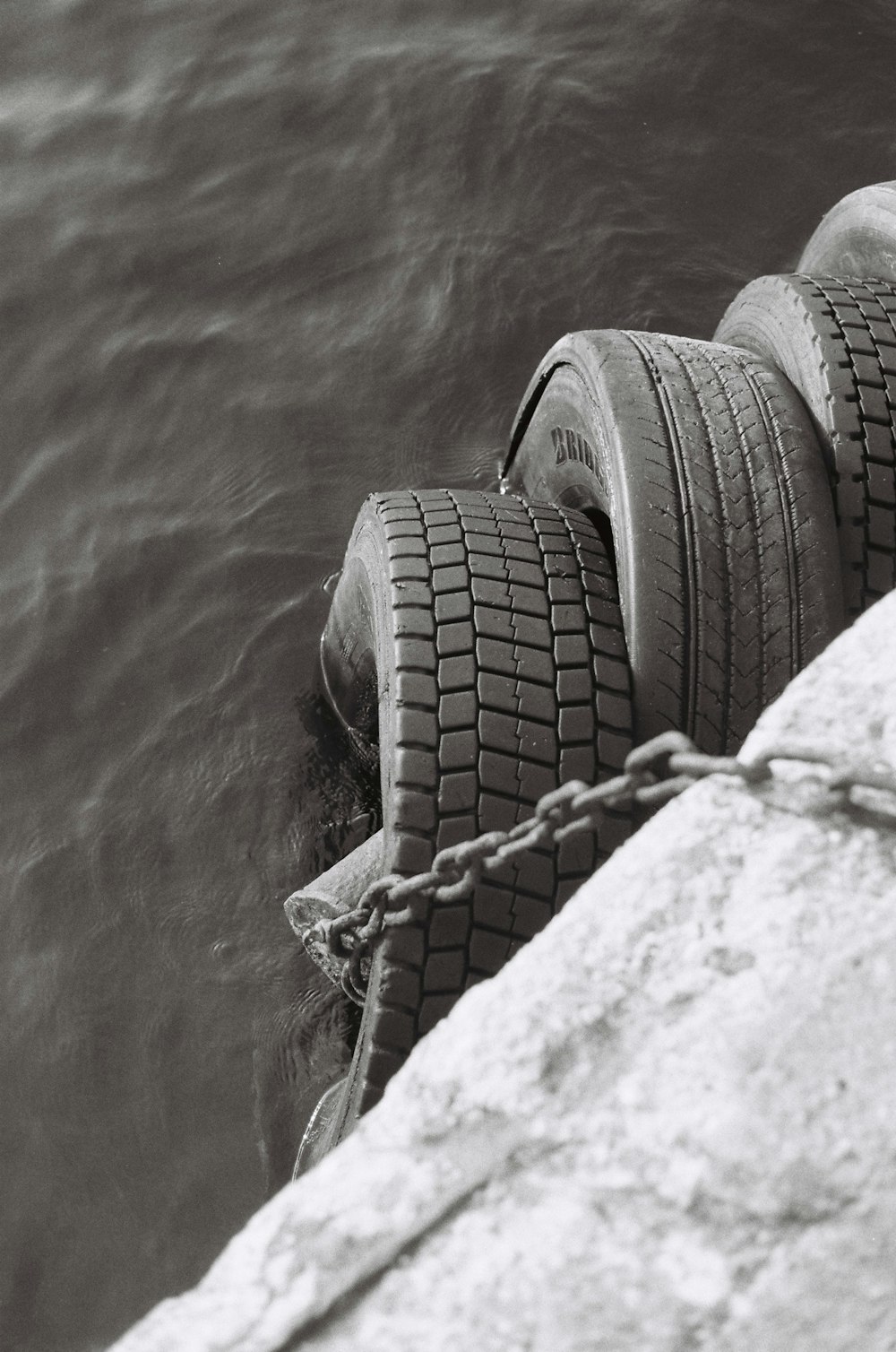 a black and white photo of a tire in the water