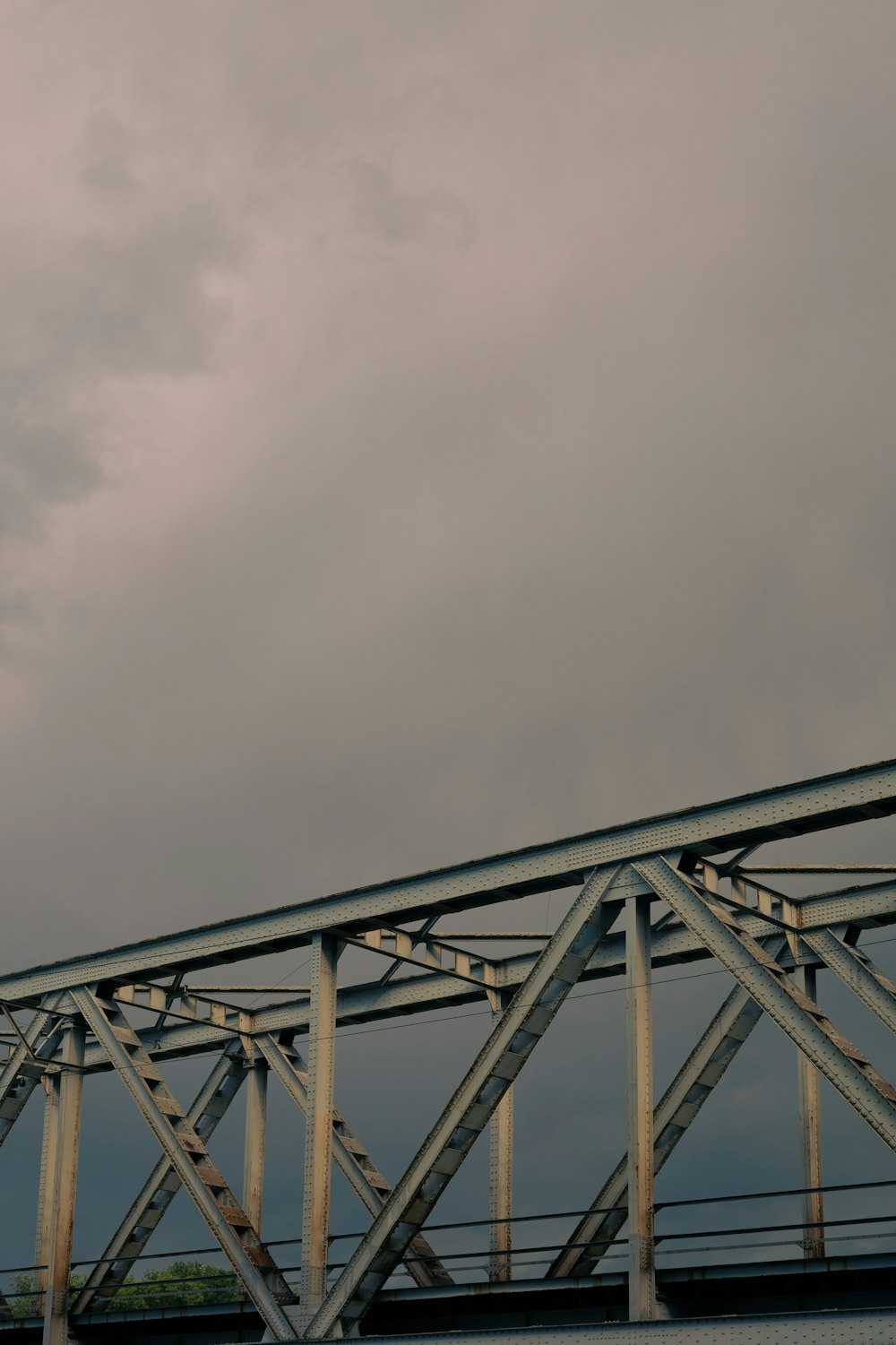 an airplane flying over a bridge on a cloudy day