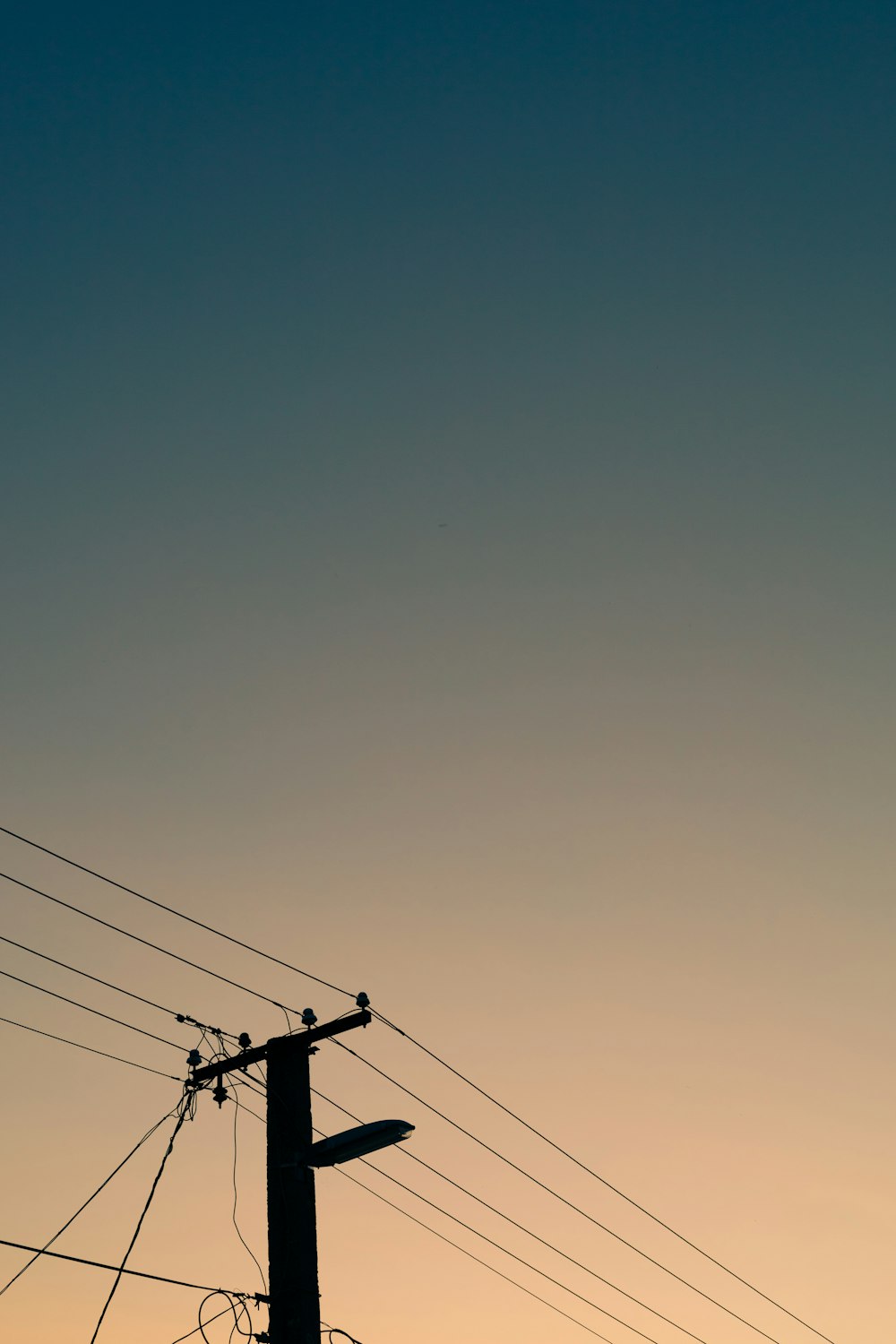 a telephone pole and power lines against a blue sky