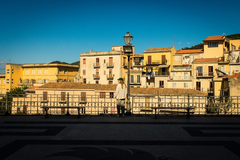 a person standing in front of a row of buildings