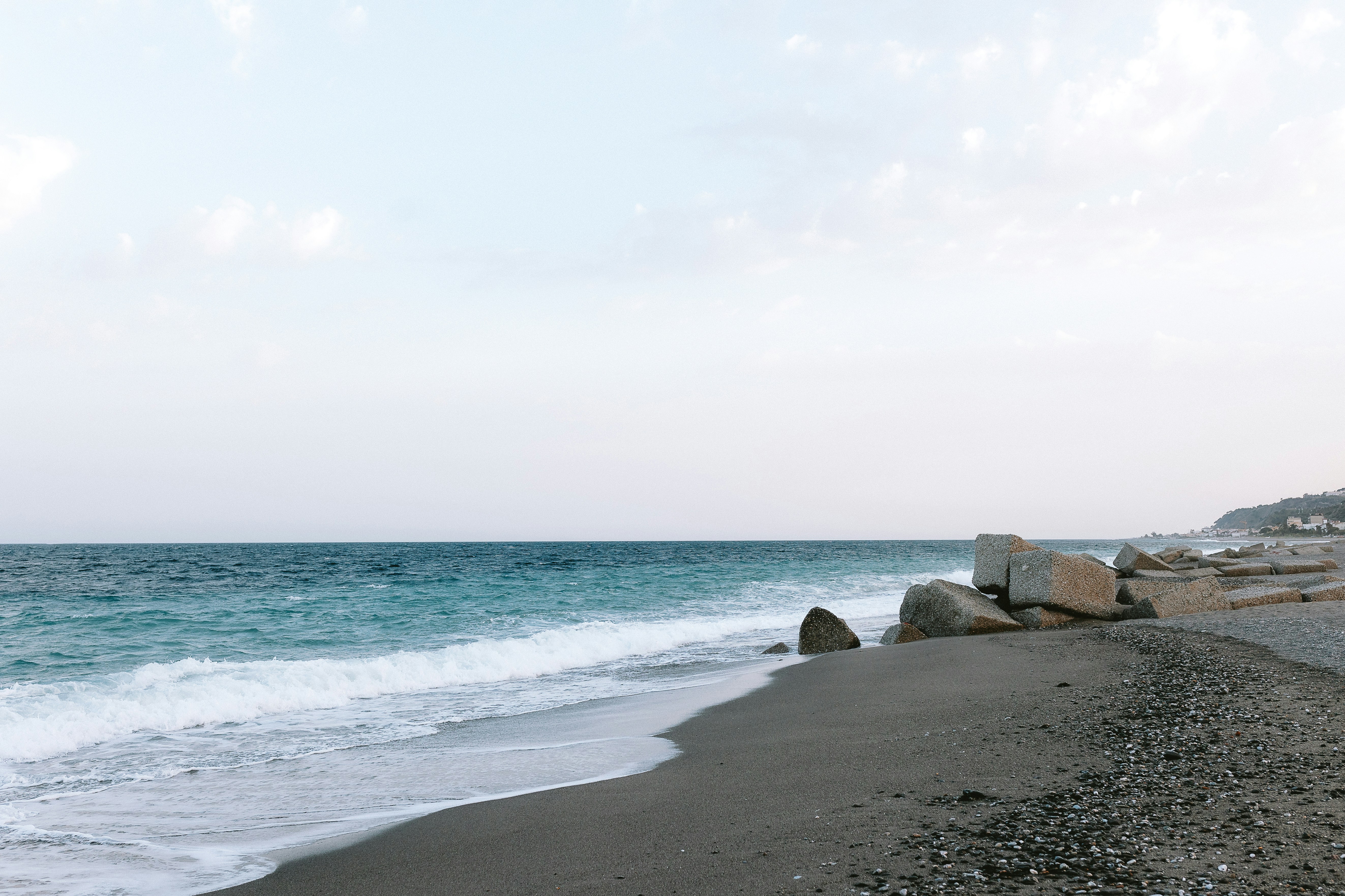 a rocky beach with waves coming in to shore