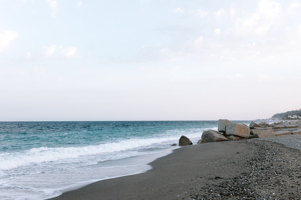 a rocky beach with waves coming in to shore