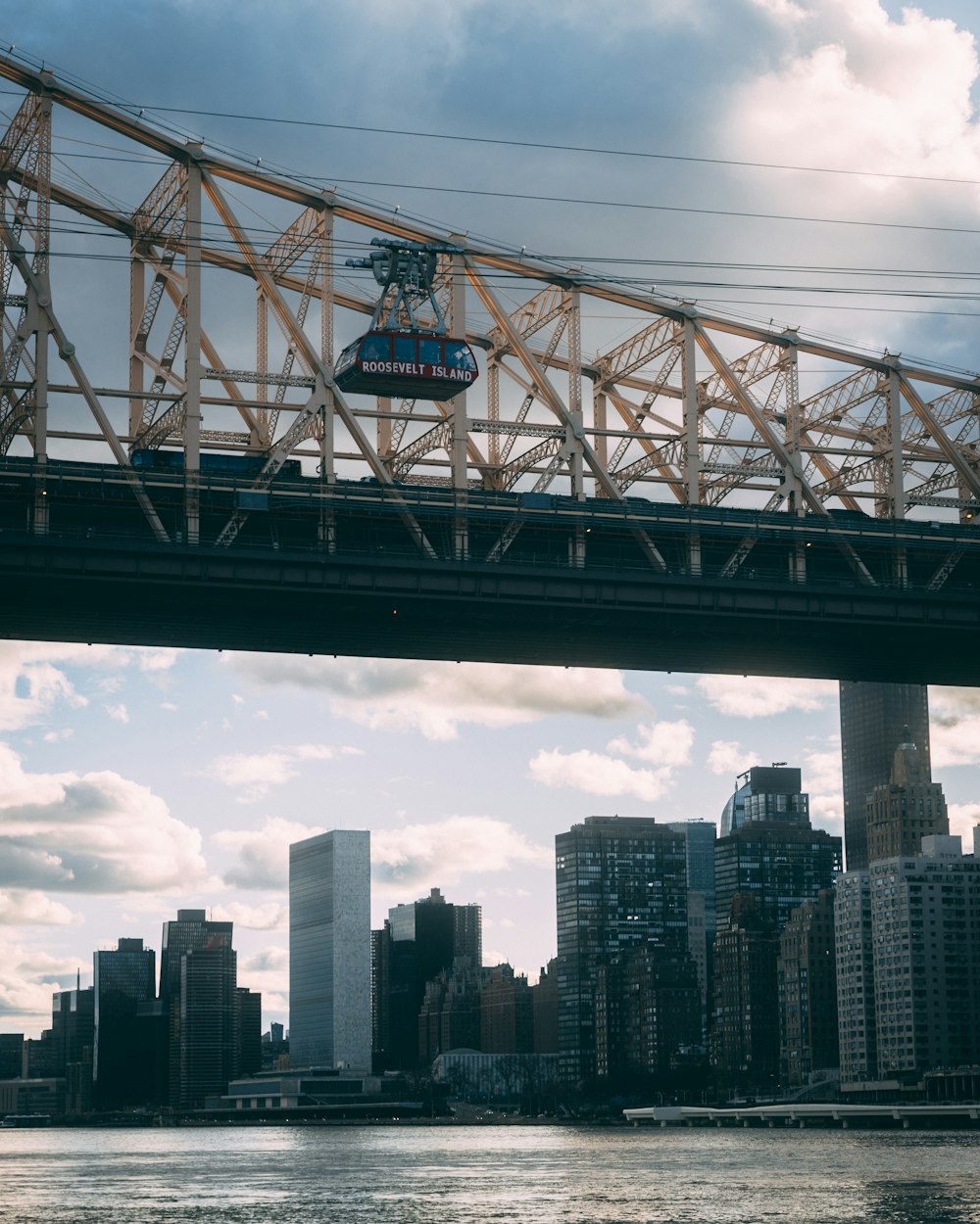 a bridge over a body of water with a city in the background