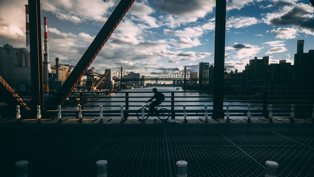 a person riding a bike across a bridge