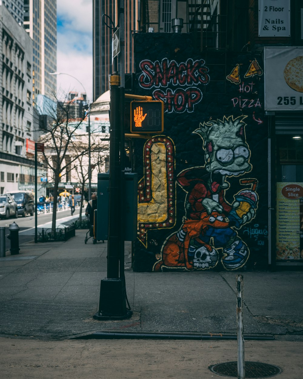 a street sign on a city street with graffiti on it