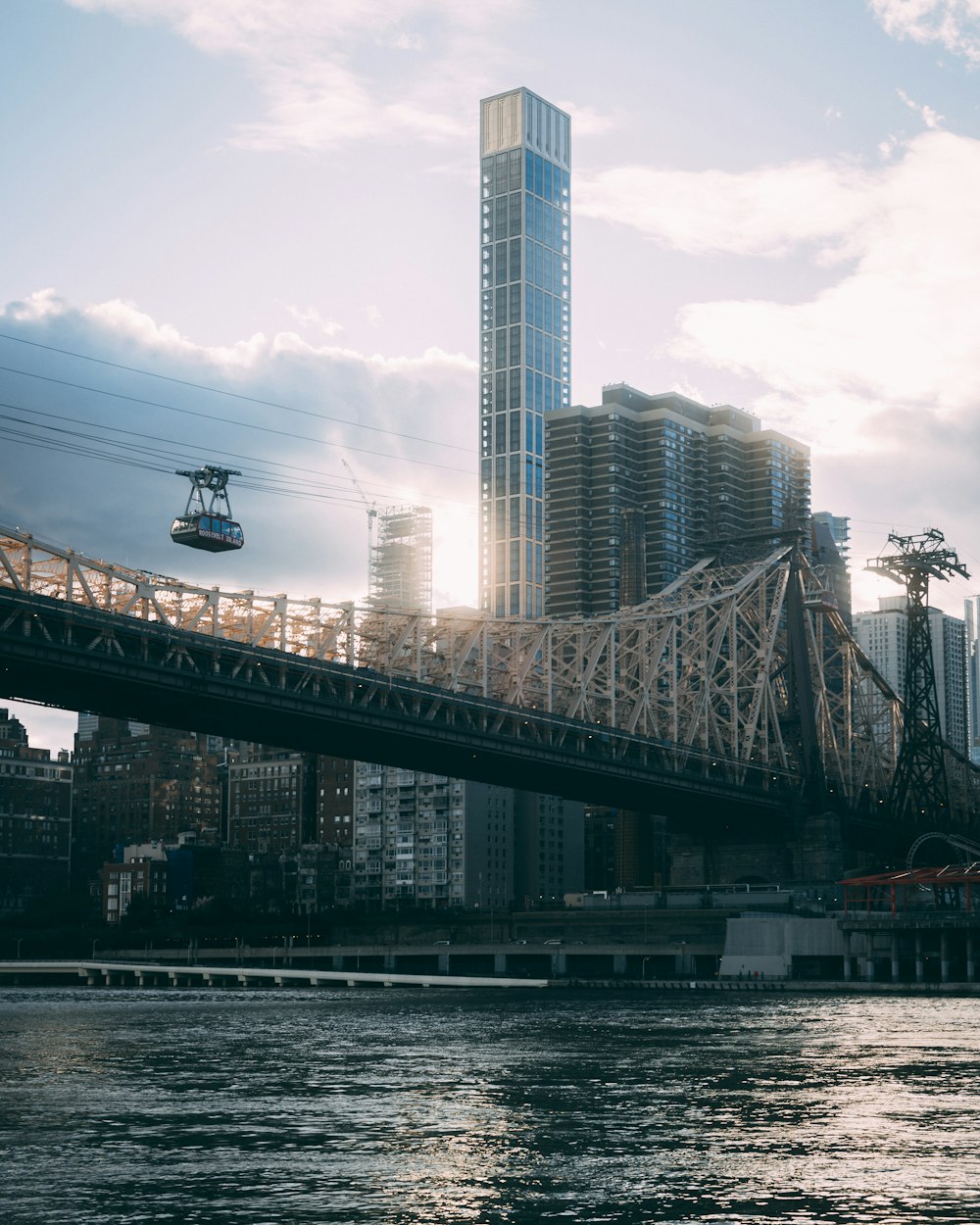 a bridge over a body of water with a city in the background