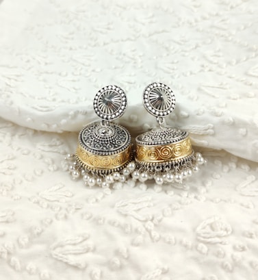 a pair of silver and gold earrings