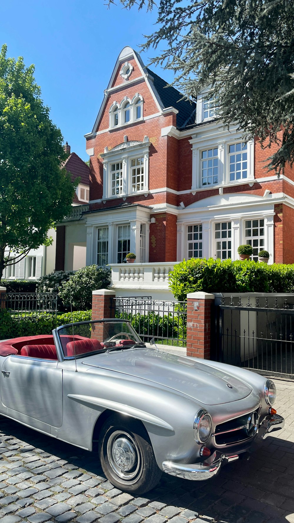 a silver car parked in front of a large house