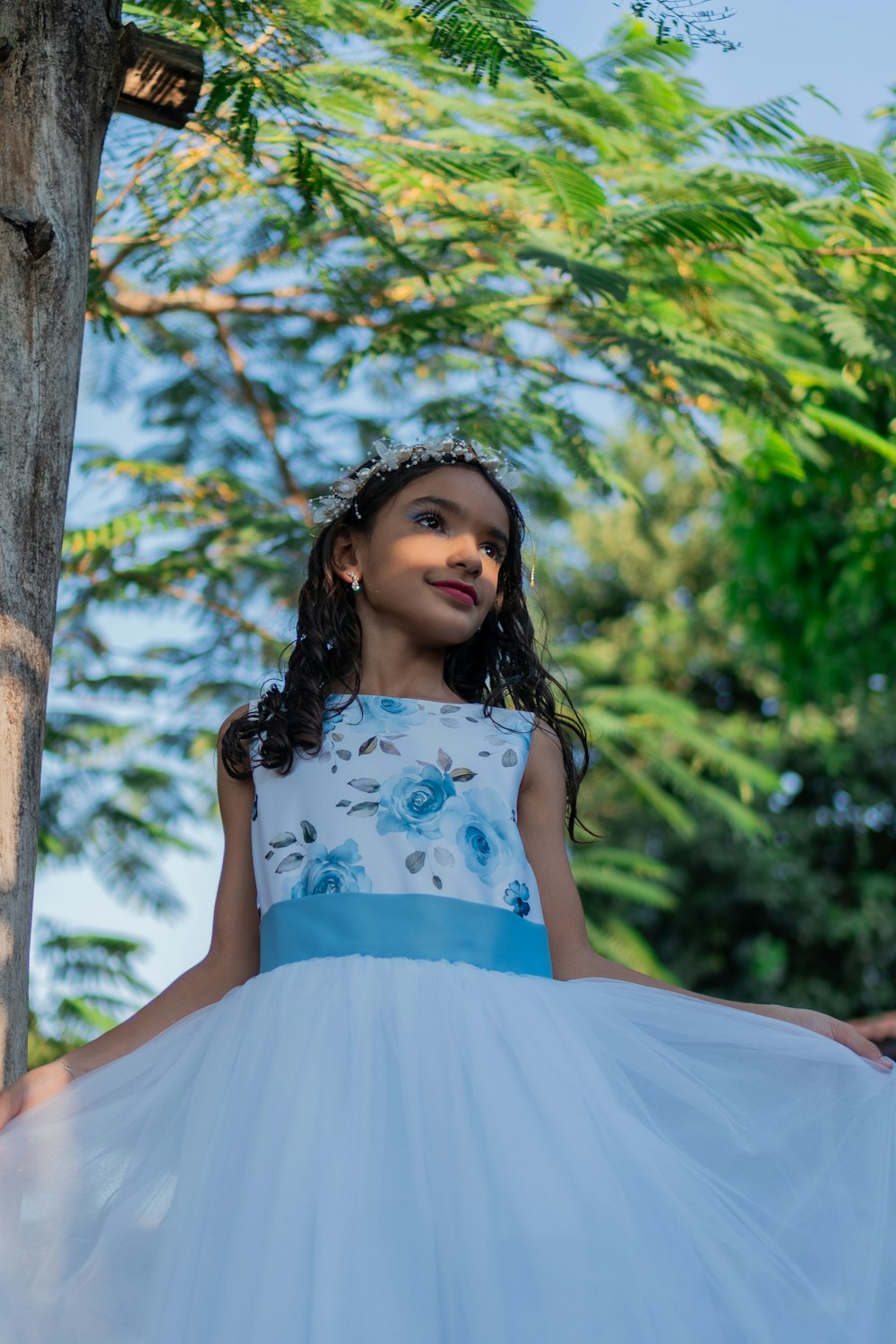 a little girl in a blue and white dress