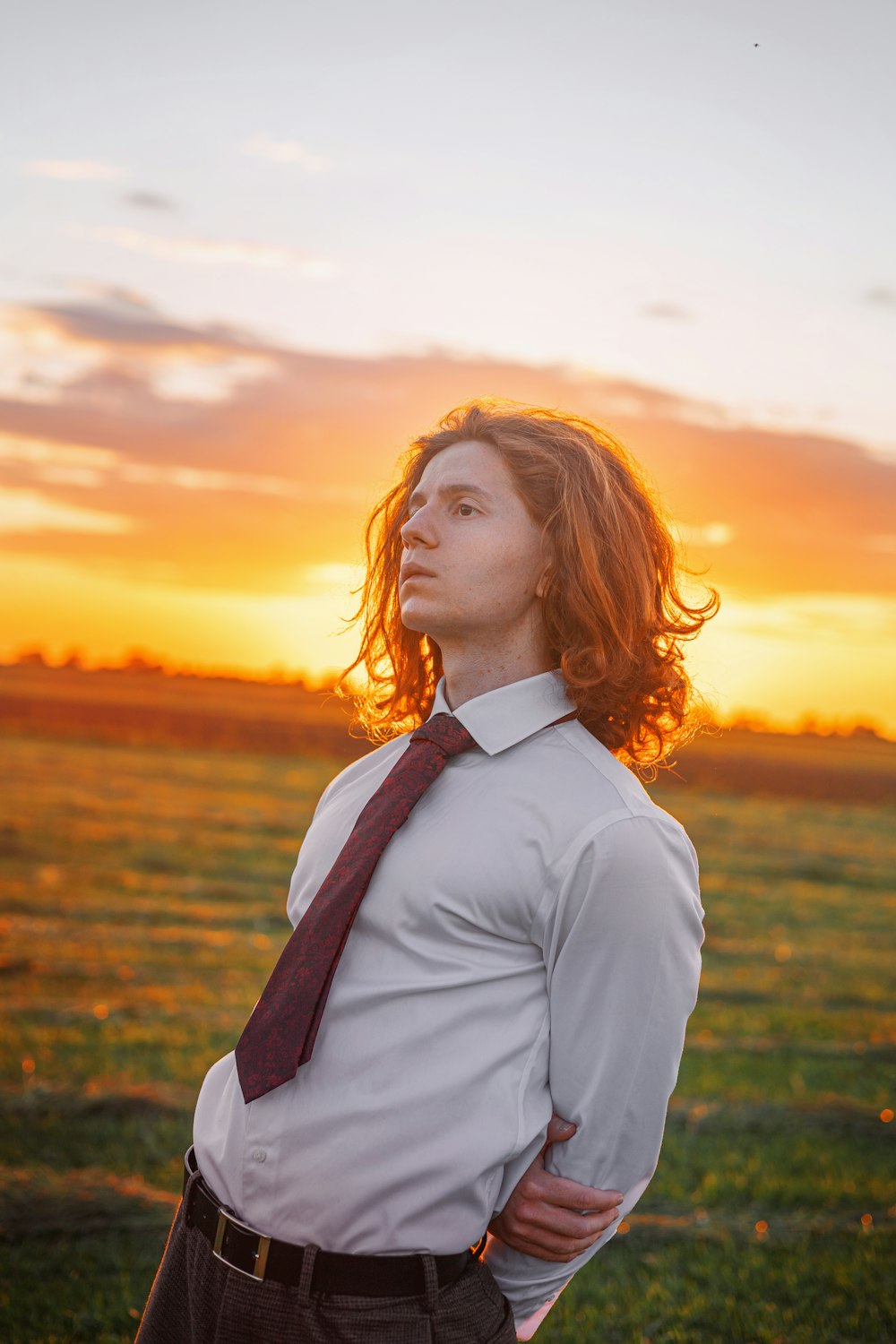 a man standing in a field with his hands on his hips