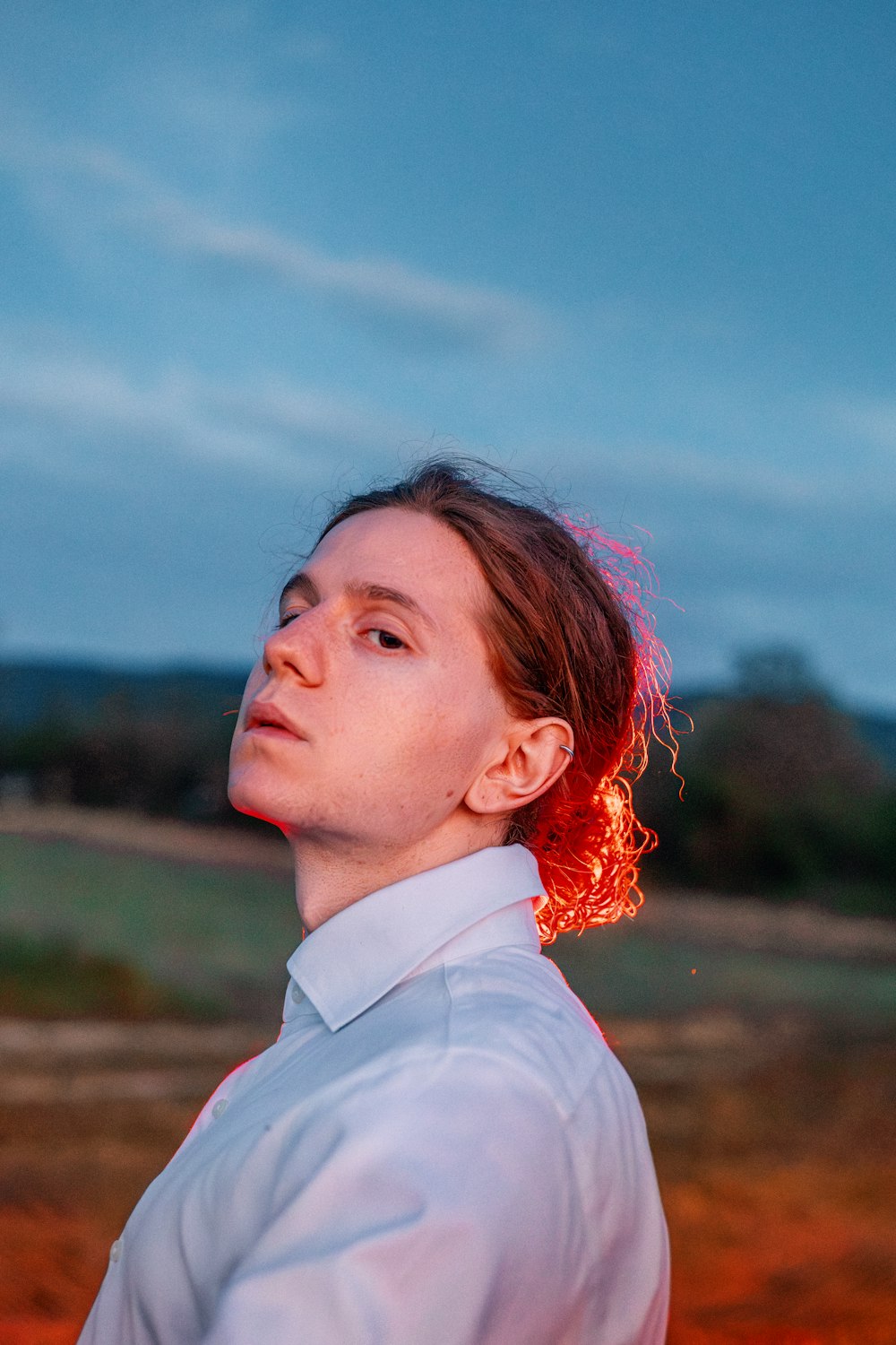 a man in a white shirt is looking up at the sky