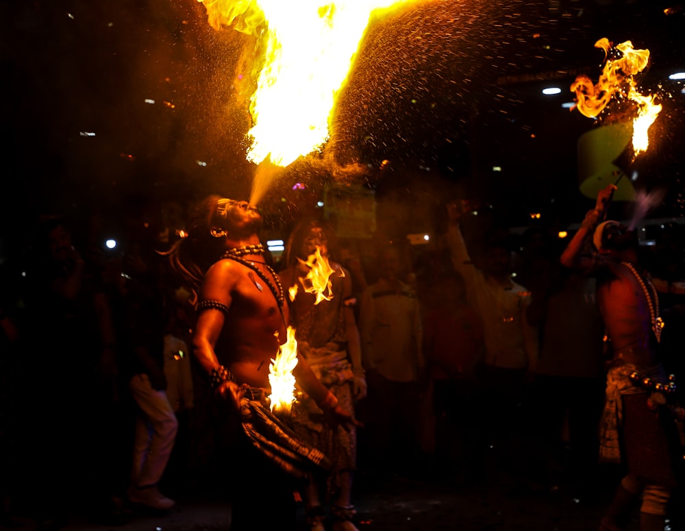 Un grupo de personas de pie alrededor de un pozo de fuego