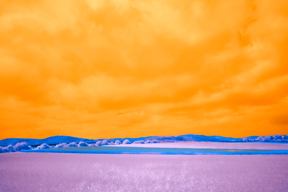 an orange and purple sky over a large body of water