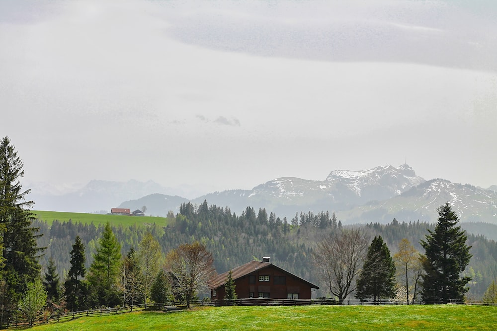 a house in a field with mountains in the background