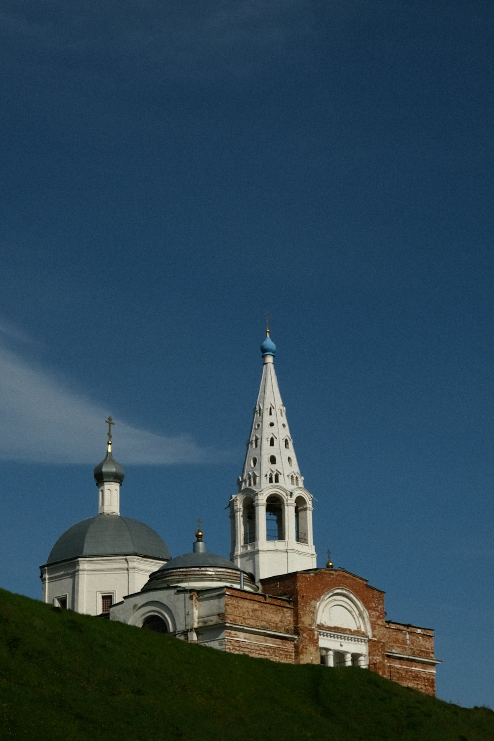 a church with a steeple on top of a hill