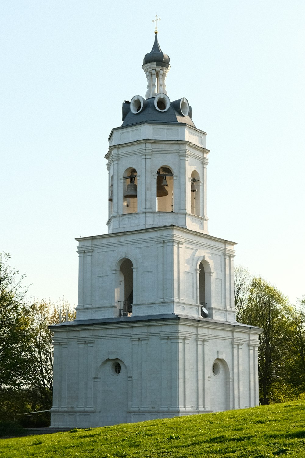 a tall white tower with a clock on it's side