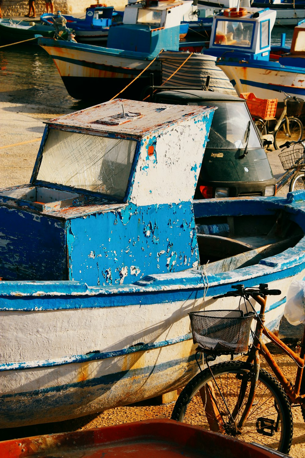 a bike parked next to a boat on a beach