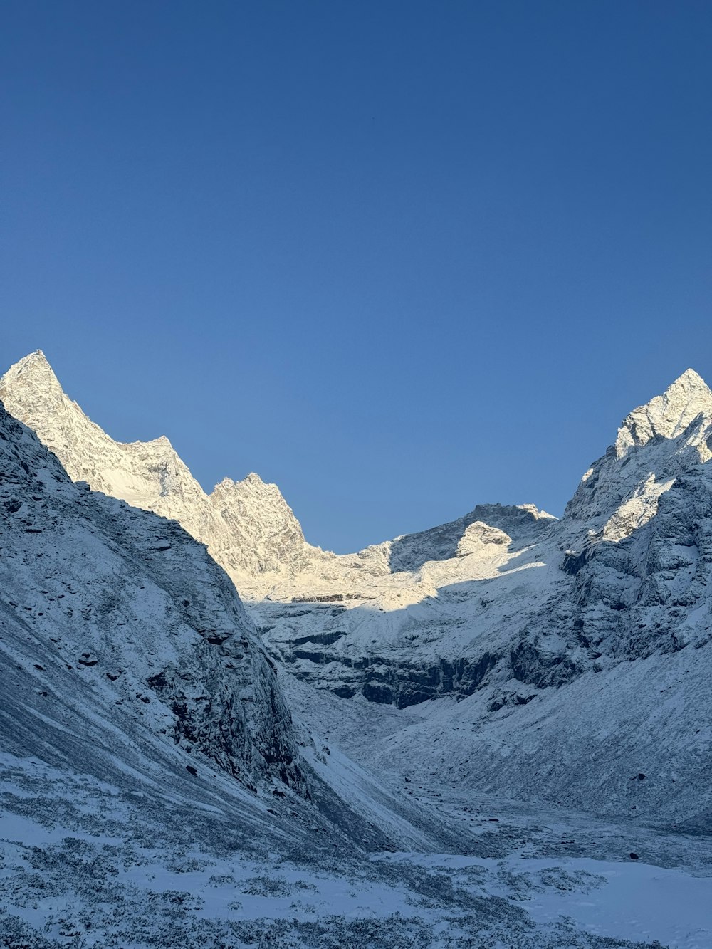 a snow covered mountain range with a clear blue sky