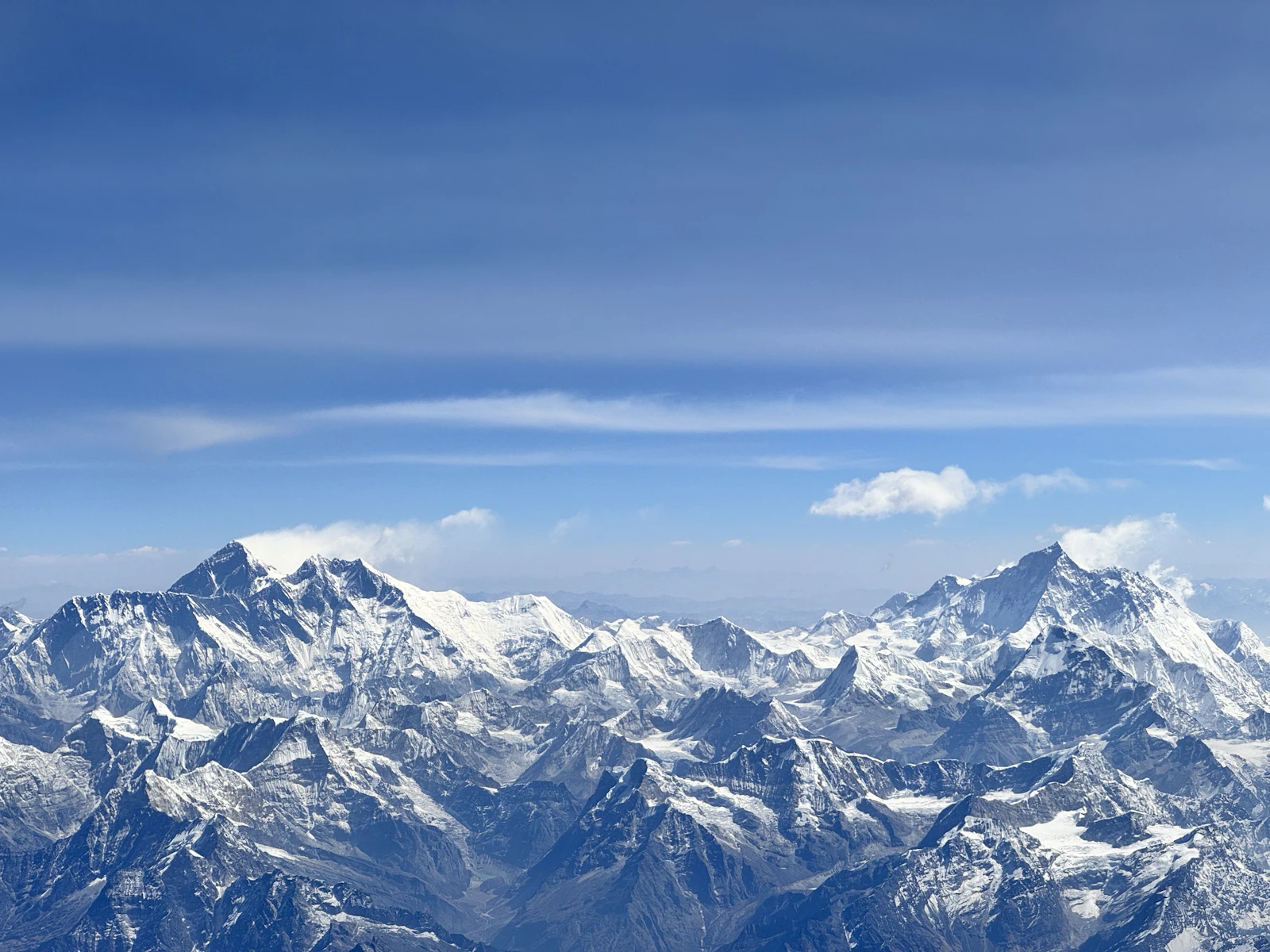 The Everest massif and its neighbouring peaks seen from an aircraft above the snow ridges of eastern Nepal