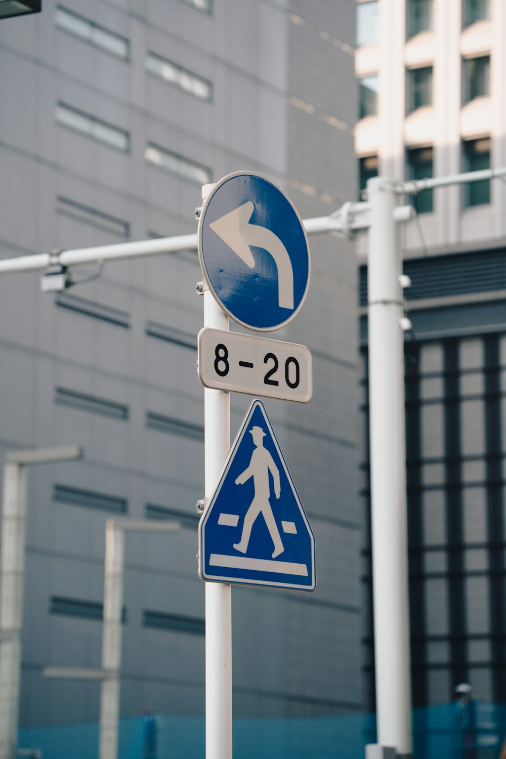 a blue and white street sign sitting on the side of a road