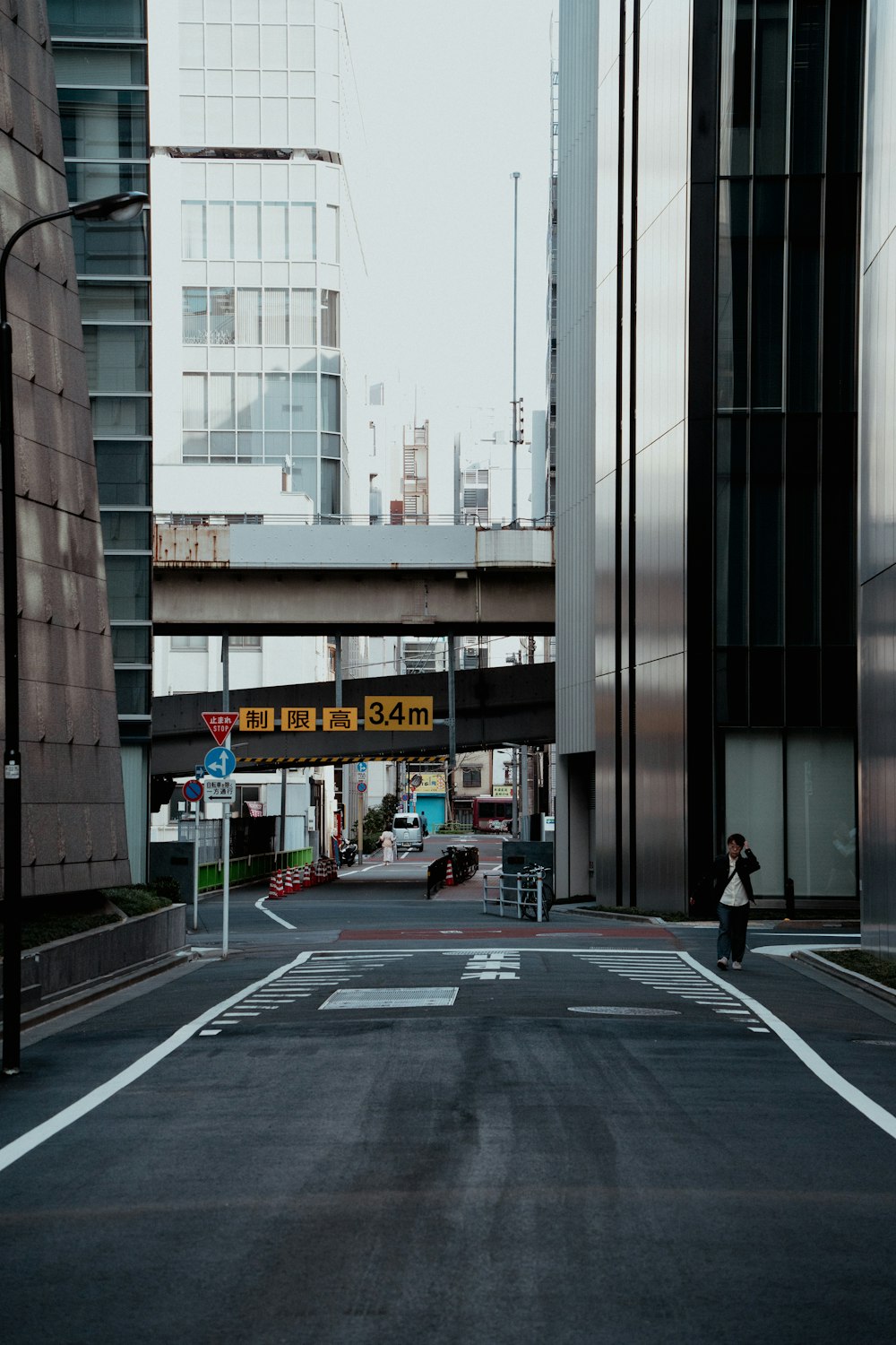 a person walking down a street next to tall buildings