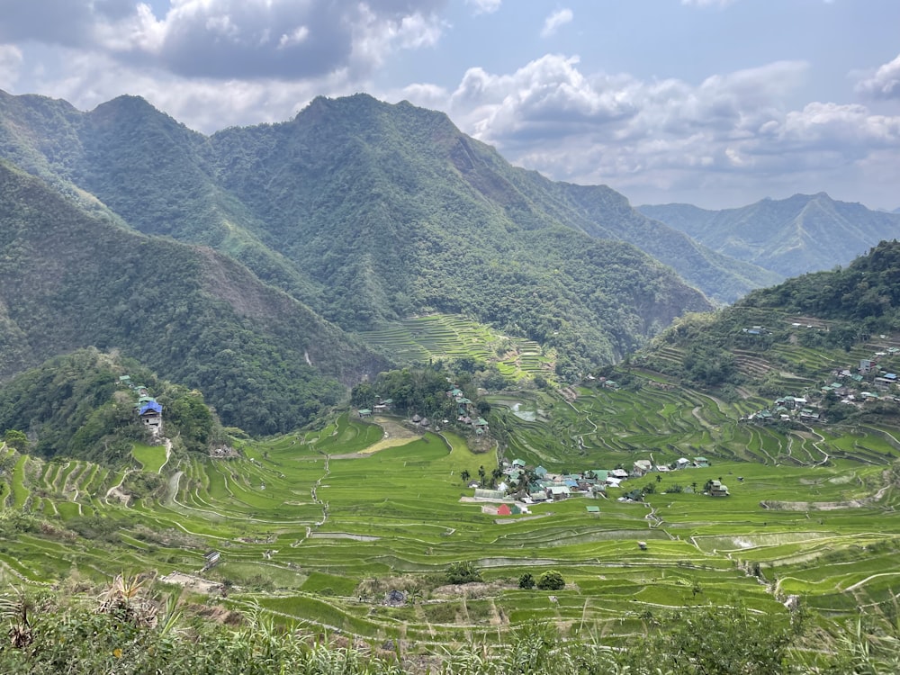 a lush green valley surrounded by mountains