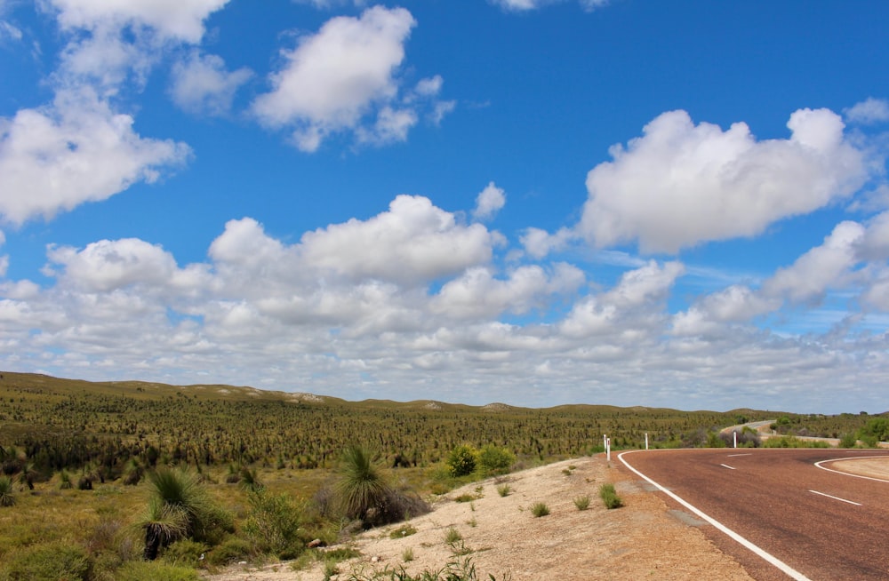 a long road with a sky filled with clouds