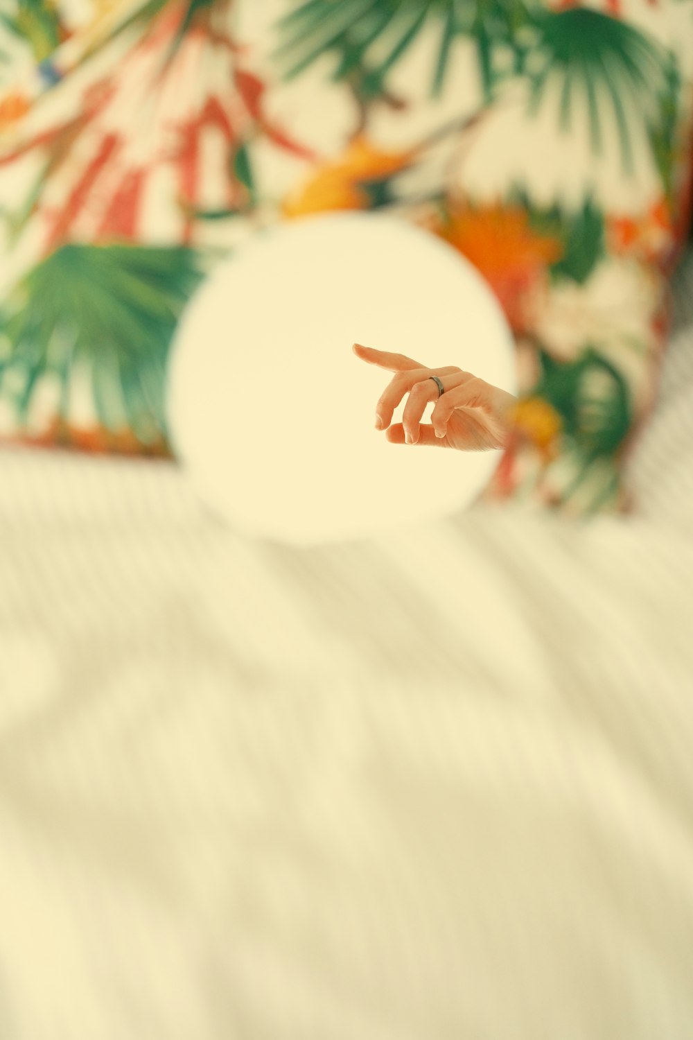 a person pointing at a white object on a bed
