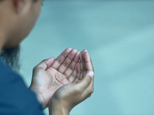 a woman holding her hands together in prayer