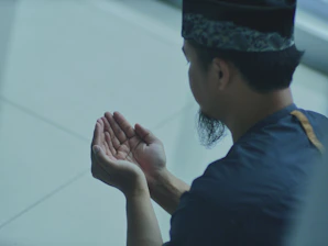 a man in a blue shirt is holding his hands together