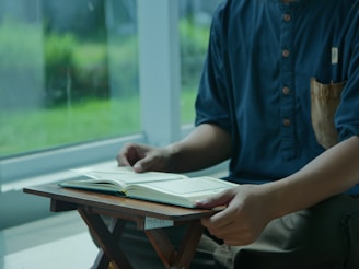 a man sitting in a chair reading a book
