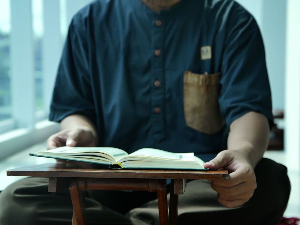 a man sitting on the floor reading a book