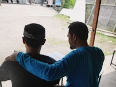 a couple of men sitting next to each other