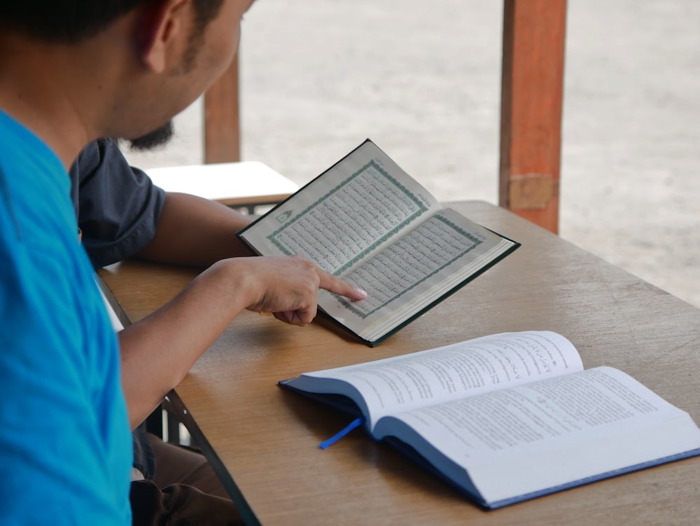 a man sitting at a table with an open book