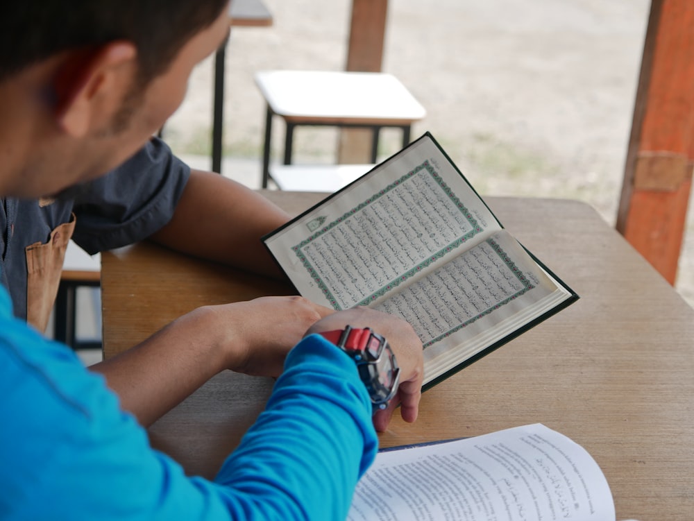 a man sitting at a table reading a book