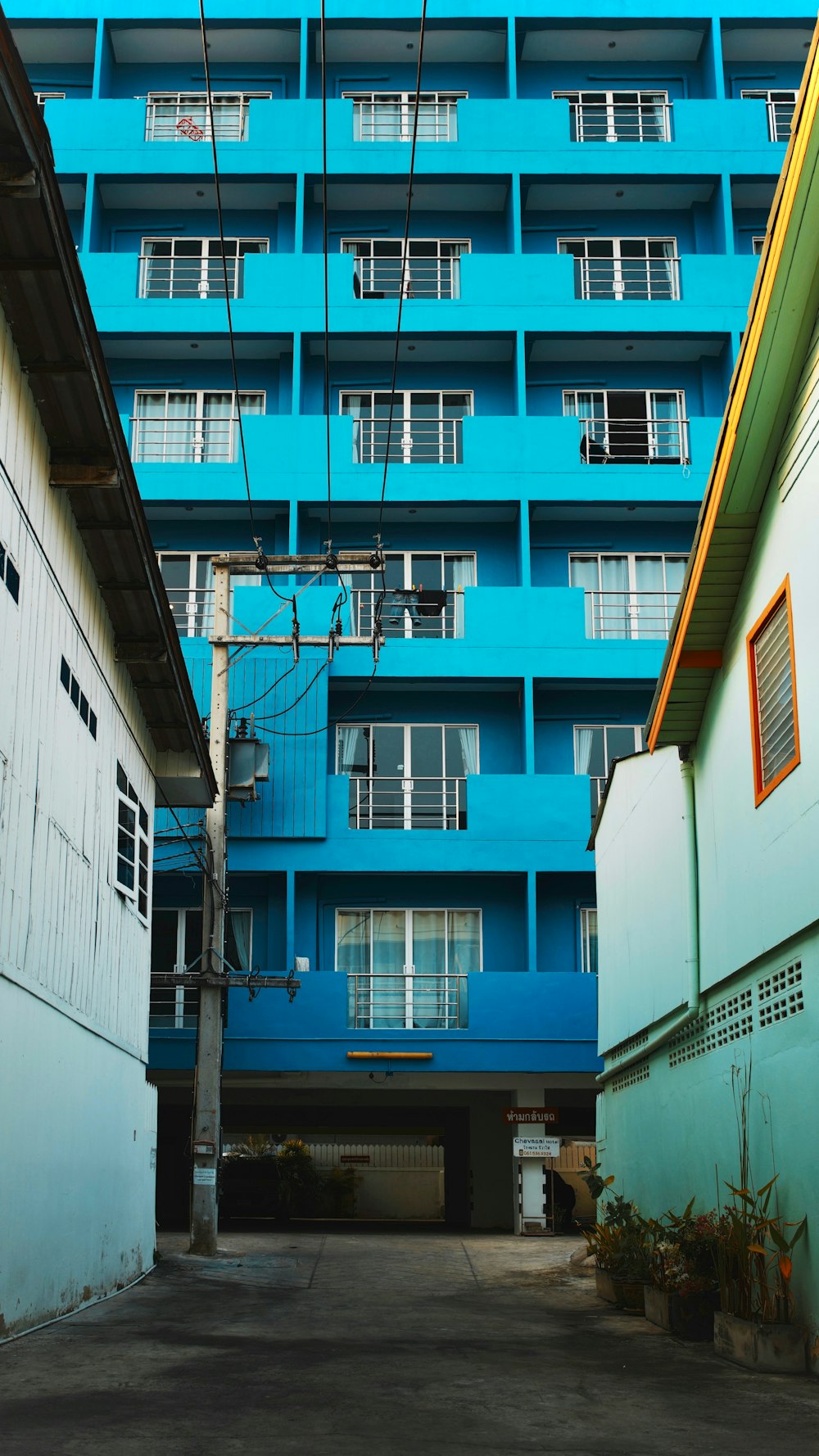 un edificio azul alto sentado al lado de un edificio blanco alto