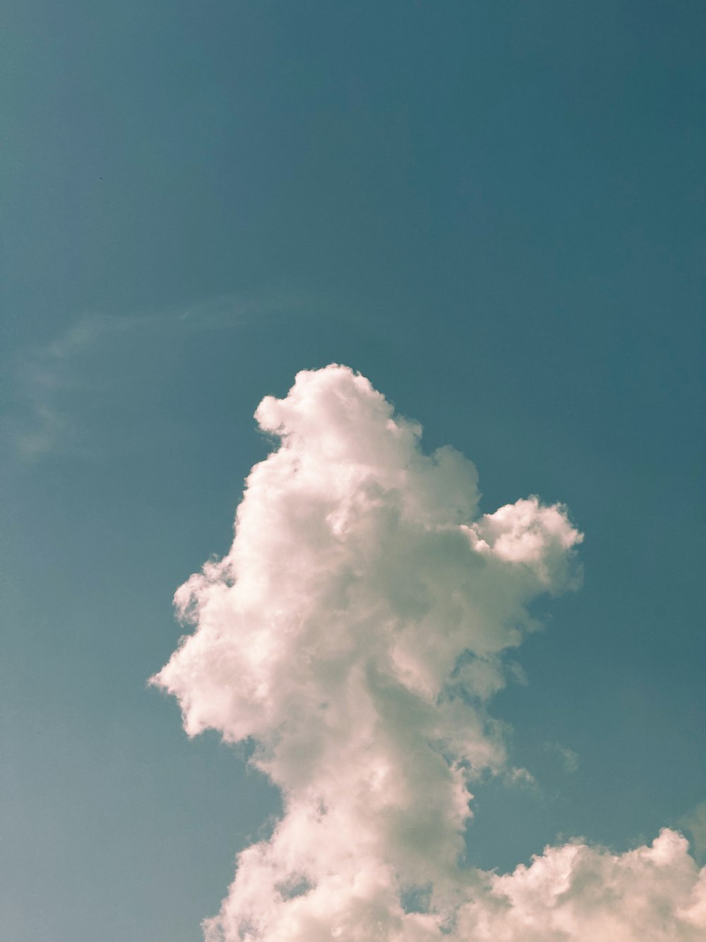 a plane flying through a blue sky with clouds