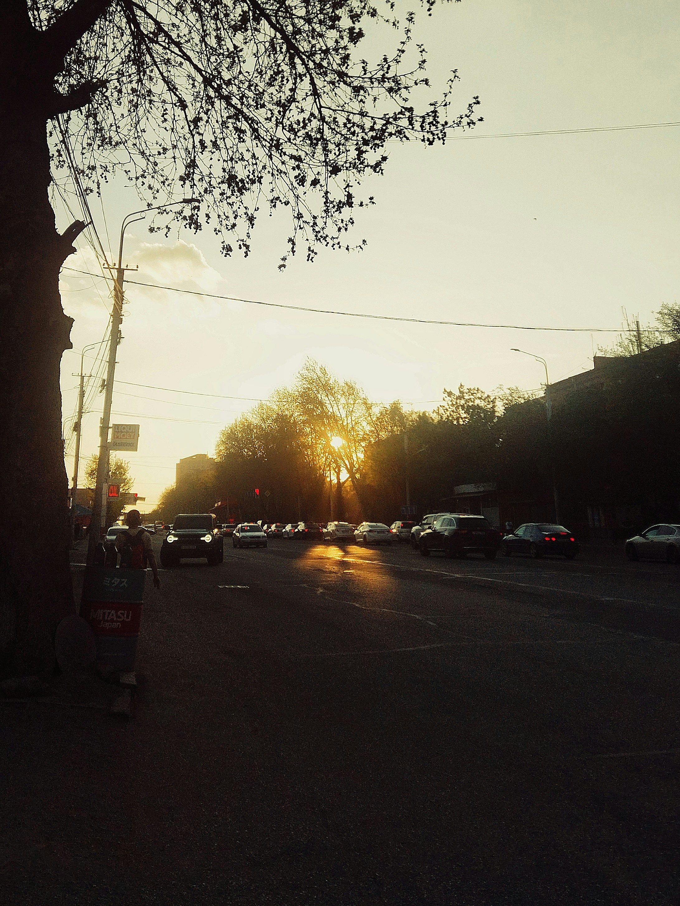 the sun is setting over a city street
