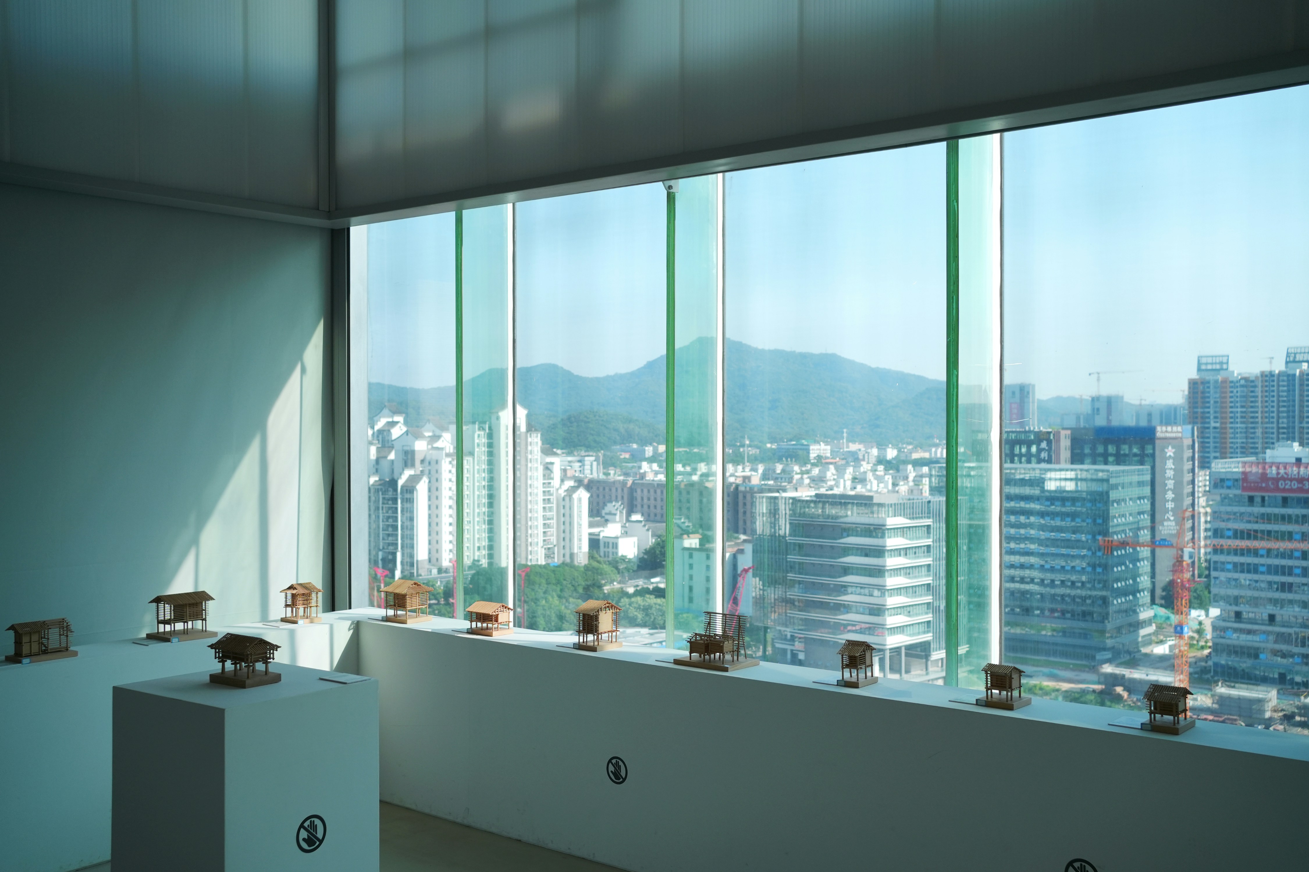 Modern apartment fitness center with floor-to-ceiling windows overlooking city skyline - Apartments with fitness center