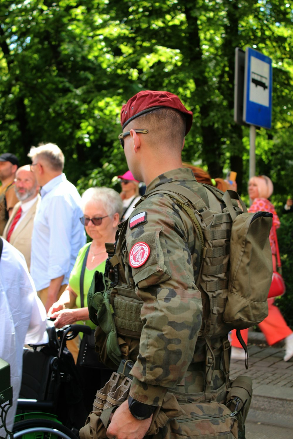 Un hombre con uniforme militar de pie junto a un grupo de personas