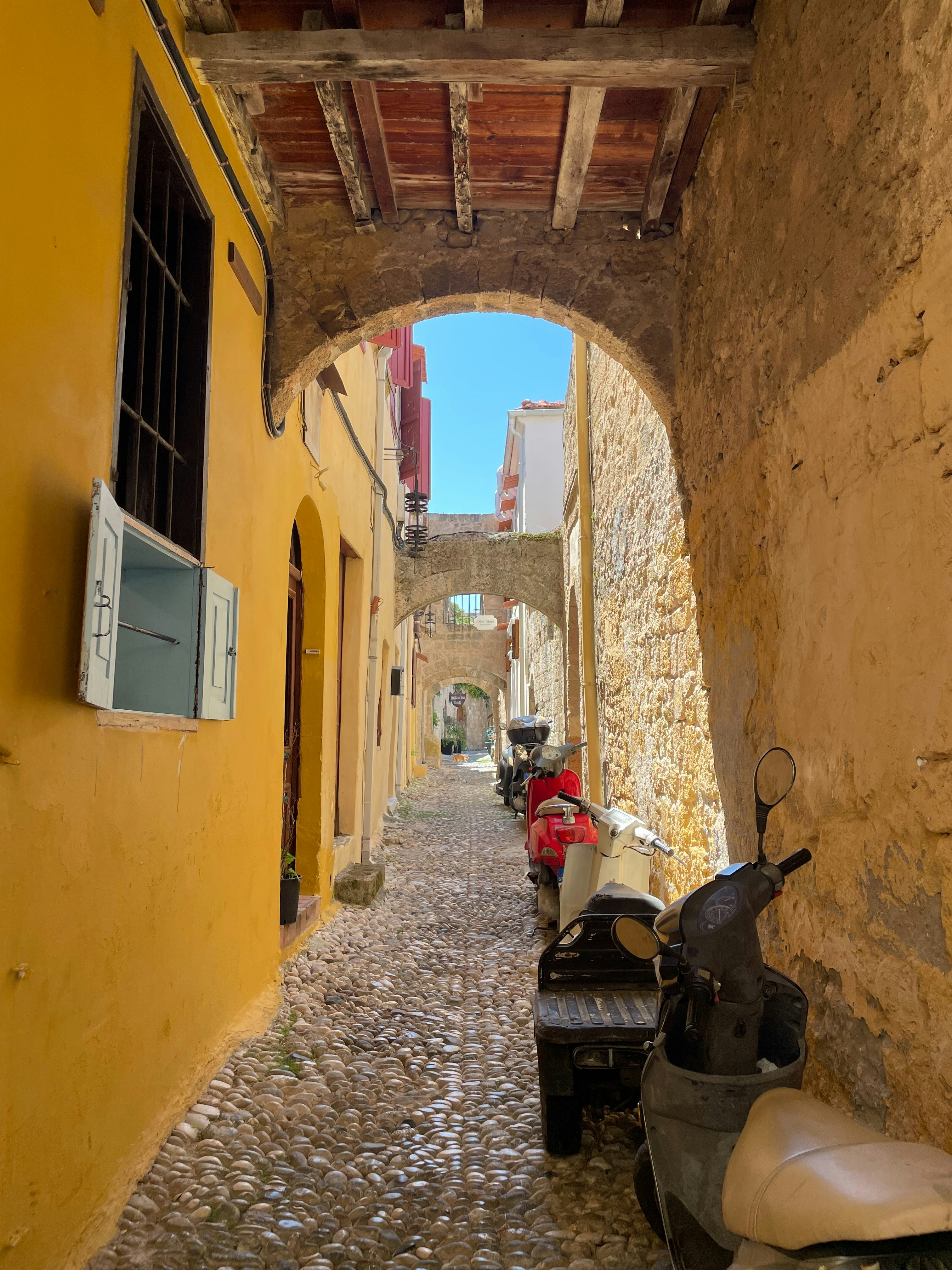 a narrow alley with scooters parked on the side