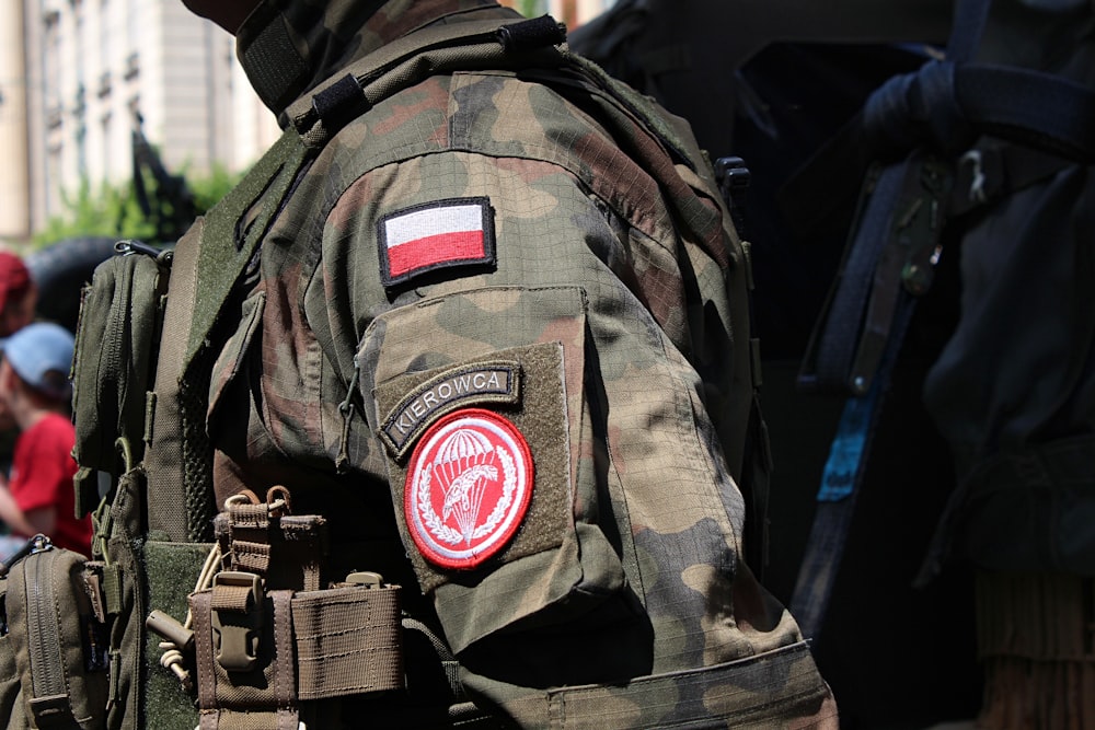 Un hombre que lleva una chaqueta de camuflaje con una bandera