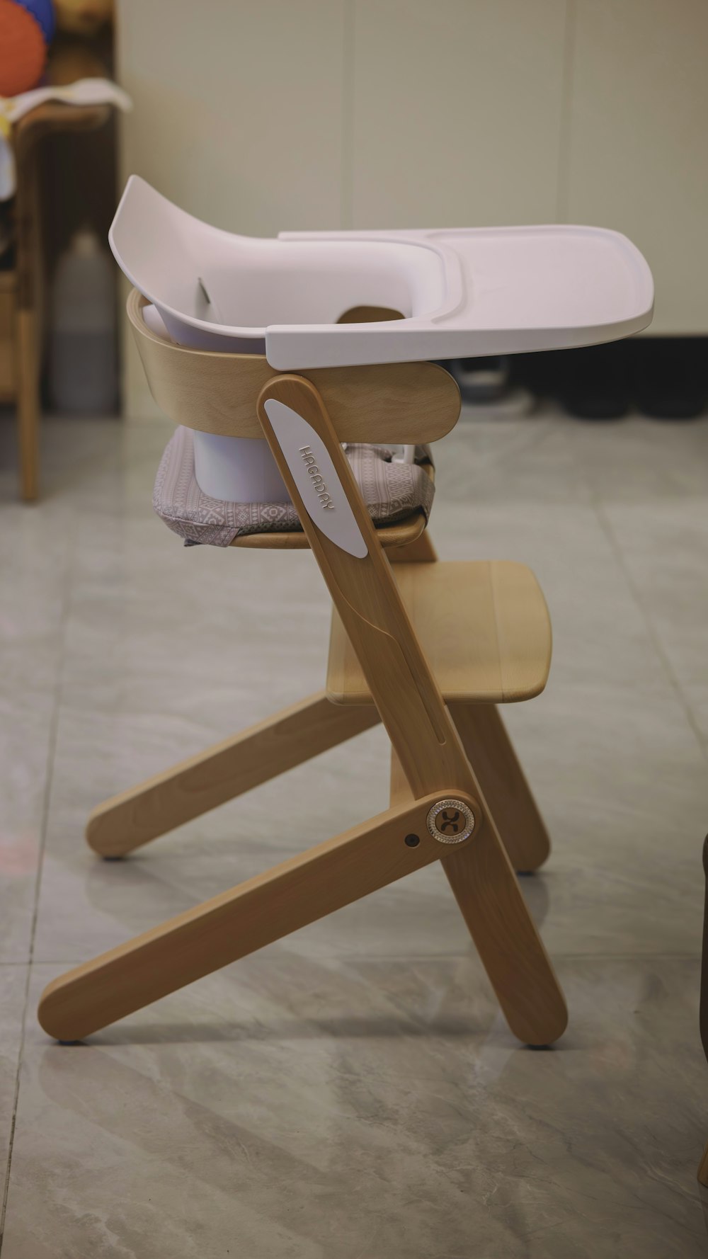a wooden high chair with a white tray on top of it