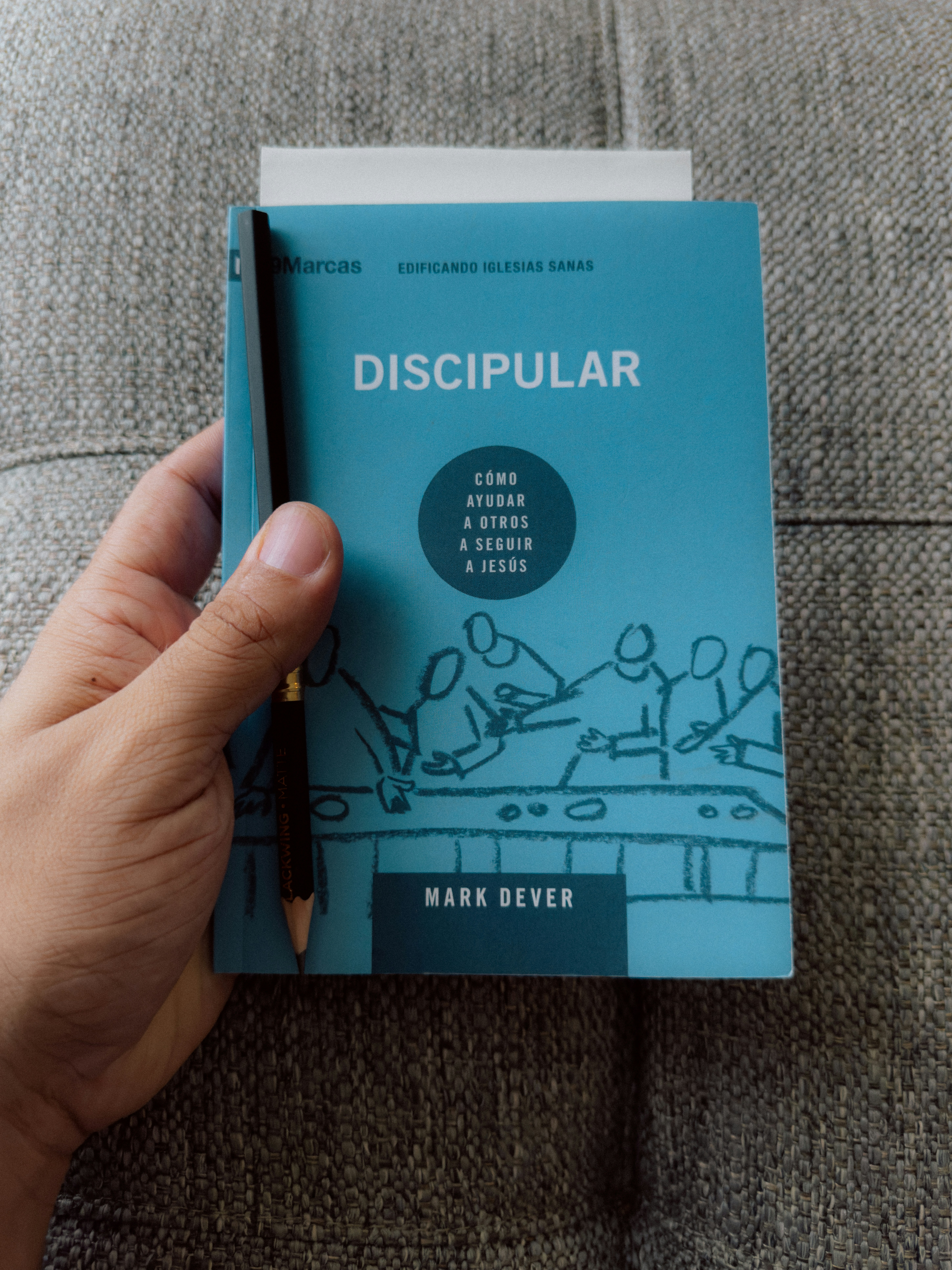 a person holding a book with a pen in their hand