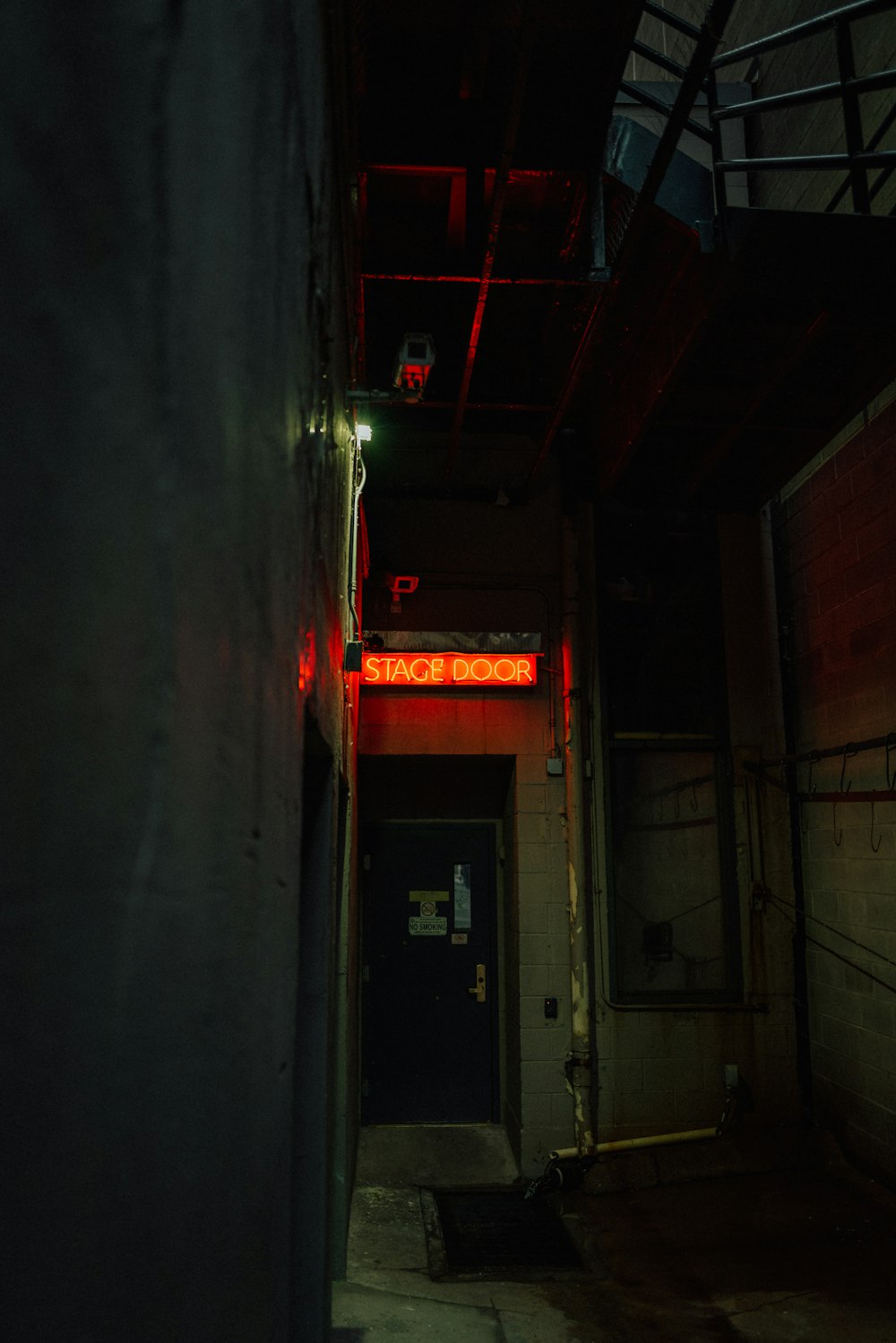 a dark hallway with a red light on the door
